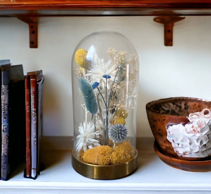 Dried flower cloche with glass dome, white and blue blooms, yellow accents, gold base