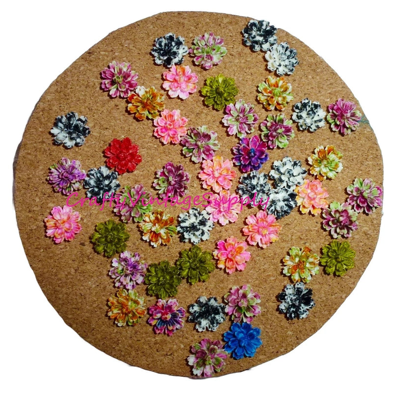 Assorted floral push pins with small carnation-style flower heads on a cork board