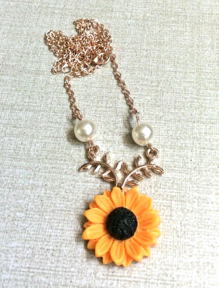 Rose gold sunflower pendant necklace with white pearl accents and black center charm