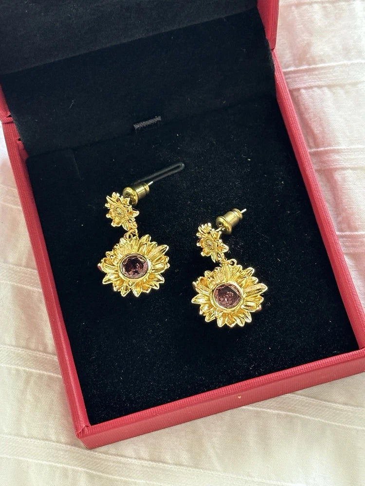 Sunflower stud earrings with gold-tone petals and purple center gemstone