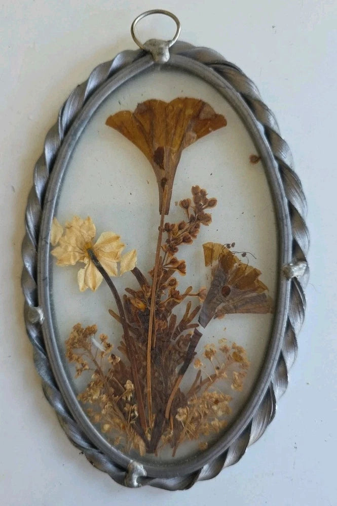 Oval pewter frame window suncatcher with dried pressed flowers in brown and gold tones
