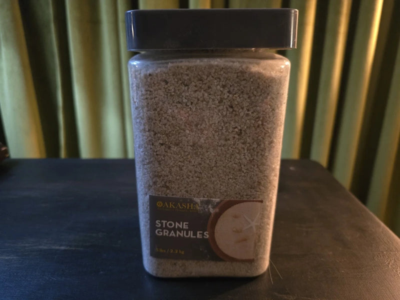 Coarse silica stone granules in clear plastic storage jar, granular sand texture