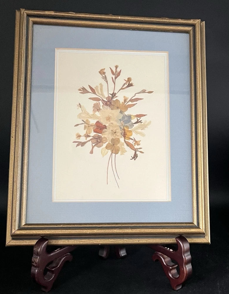 Framed pressed dried flower wall art with beige and brown blooms, gold frame, white mat