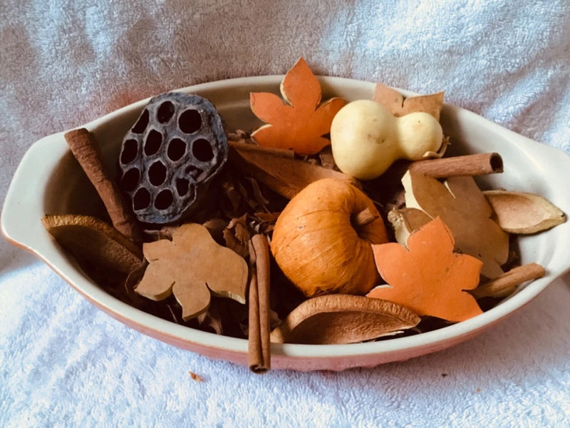 Fall potpourri mix in shallow bowl, with orange pumpkins, beige pods, and leaf shapes