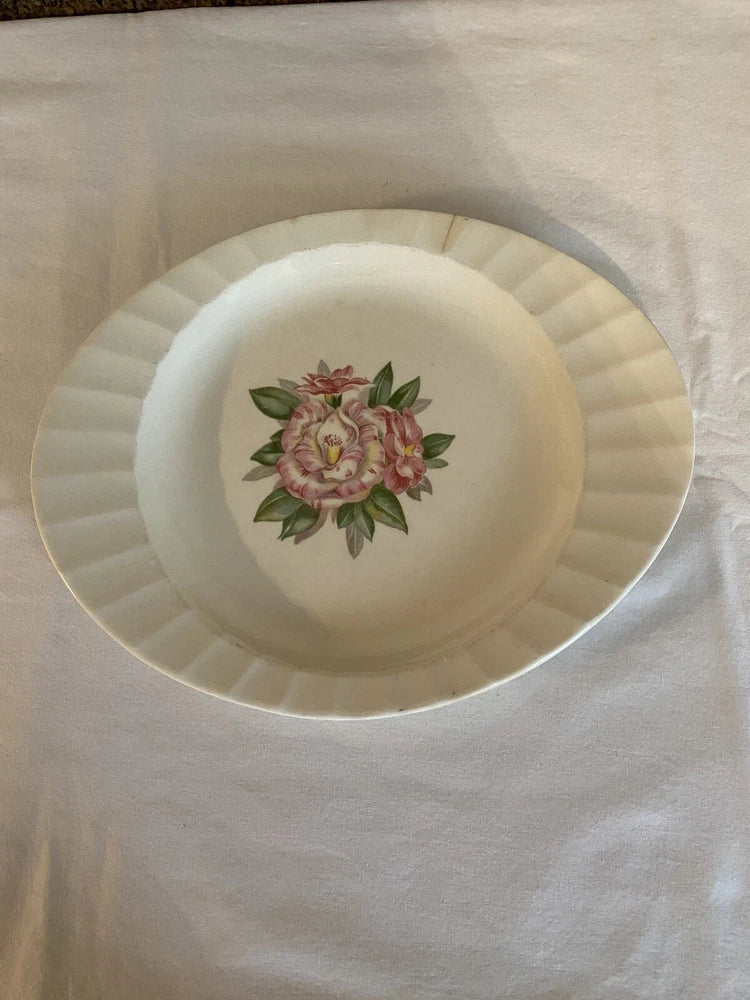 Round china serving platter with pink peony-style floral center and scalloped rim