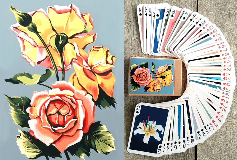 Floral playing card deck with roses and lily backs, cards fanned in hand