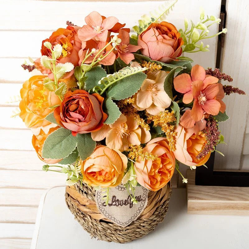 Artificial peony camellia flower bouquet ornament with peach and orange blooms in a woven basket