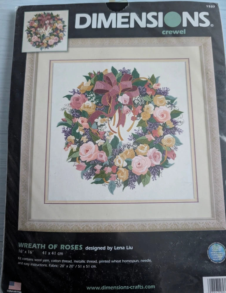 Crewel embroidery kit with rose wreath design on printed fabric in a frame