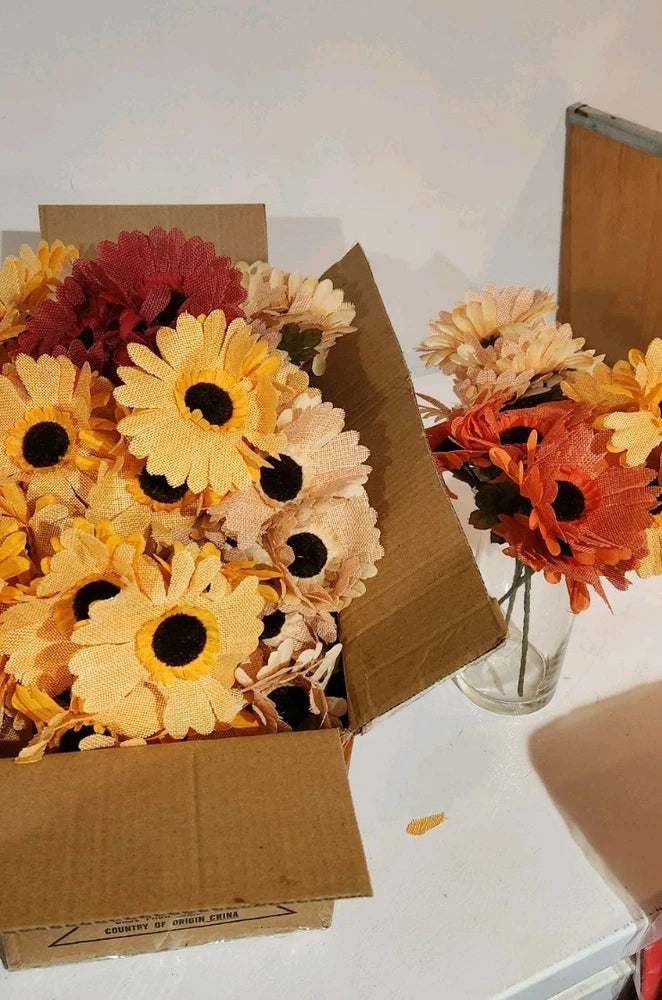 Burlap-wrapped faux sunflower flowers with mixed colors in a cardboard box