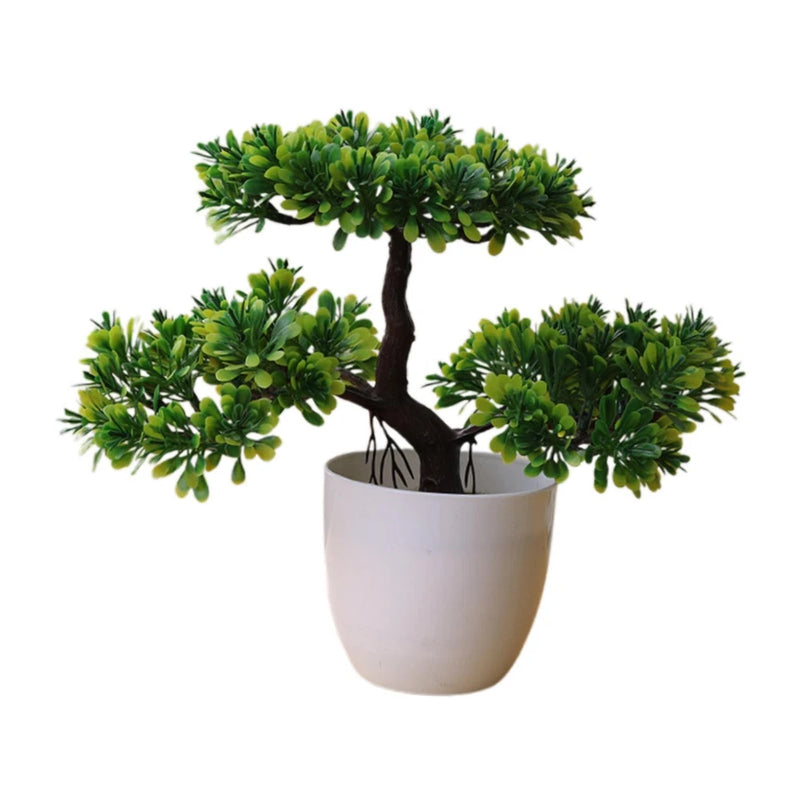 Small artificial bonsai tree with spreading green leaves in a white pot