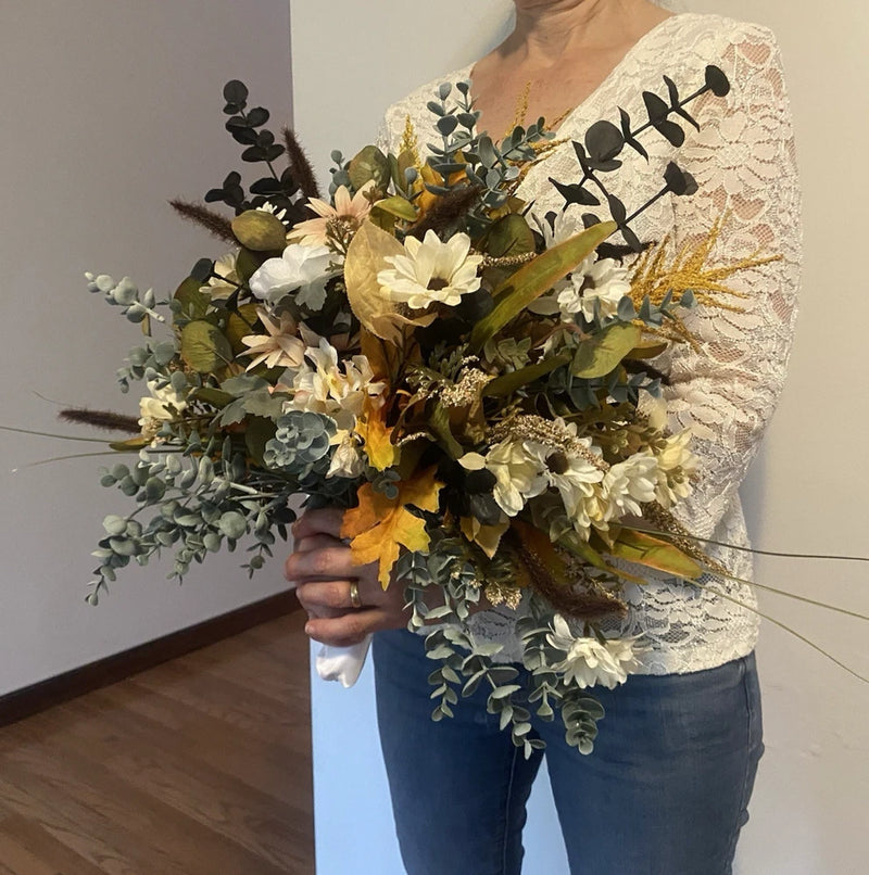 Handmade faux wedding bouquet with white and yellow flowers and green leaves