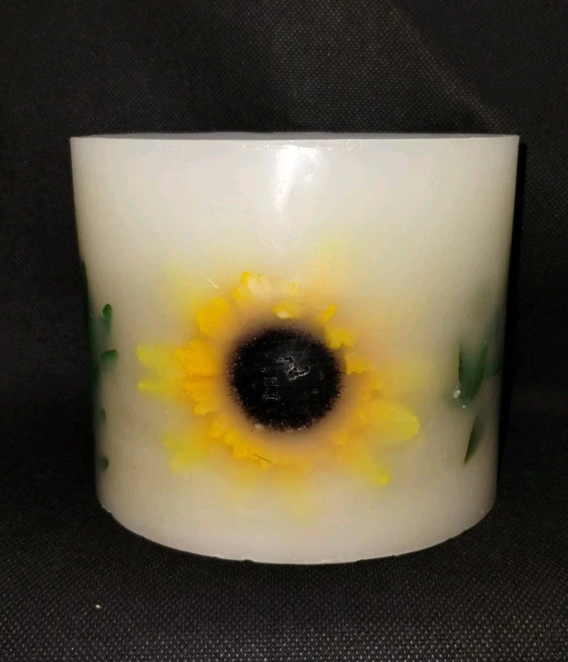White glow-through botanical candle with yellow sunflower design and green leaves