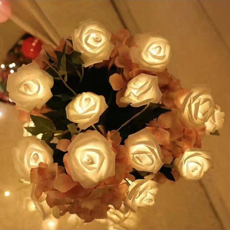 LED rose fairy lights string with warm white flower heads and green leaves