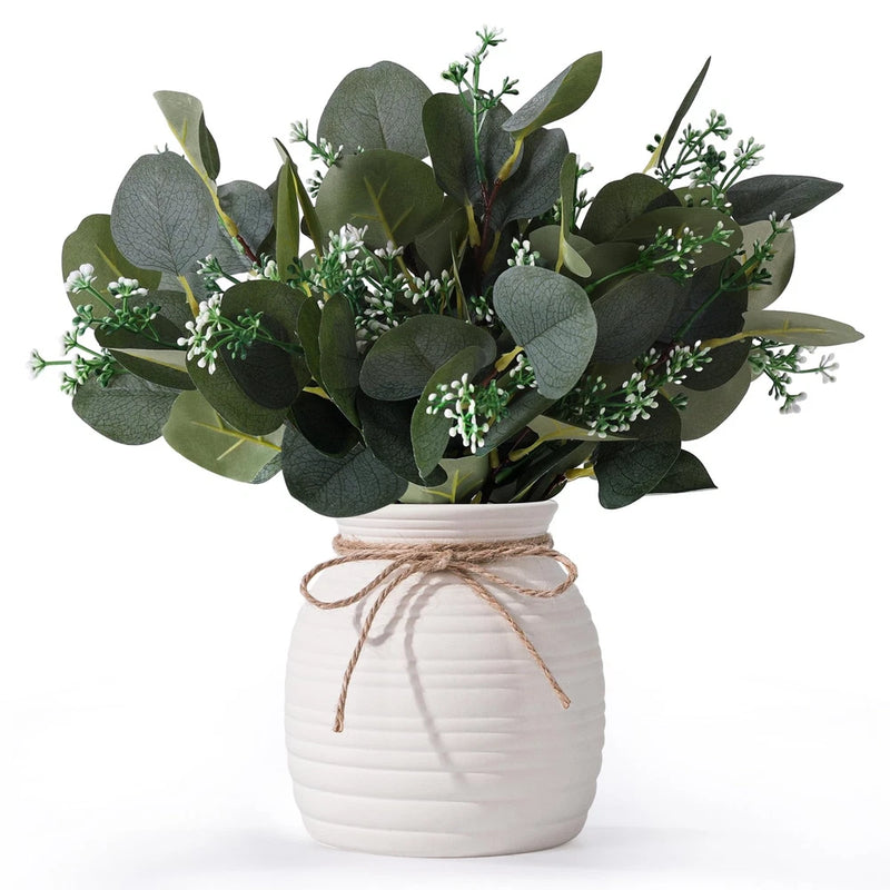 Ceramic white vase with faux eucalyptus greenery and small white blooms