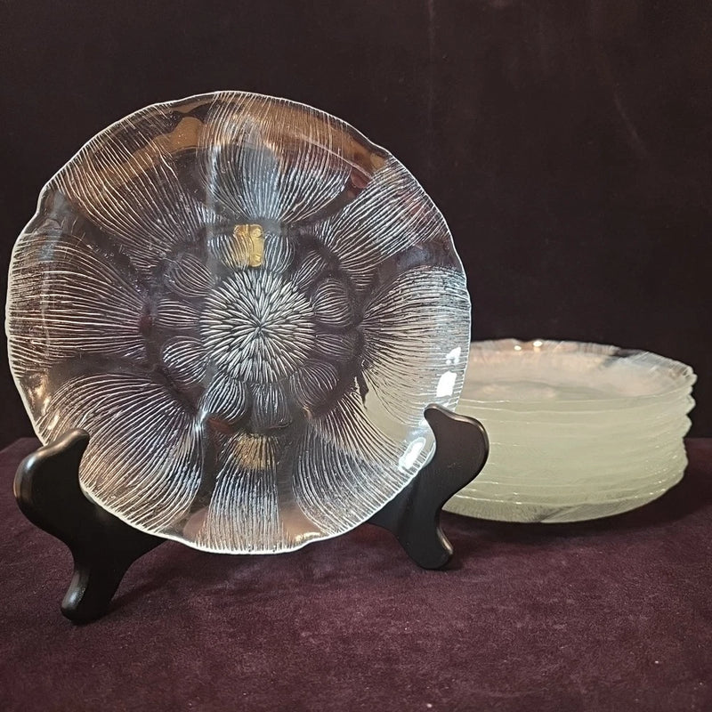 Clear glass dessert plate with embossed sunflower and floral pattern, on display stand