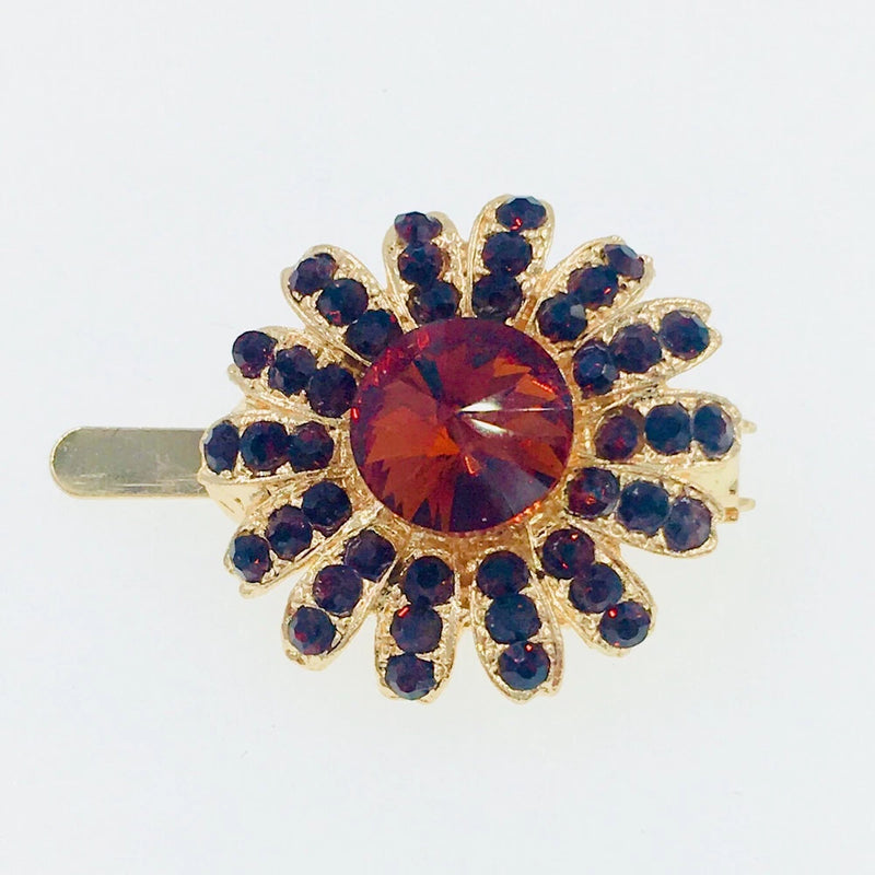 Gold-tone sunflower rhinestone hair clip with red center crystal and dark blue stones