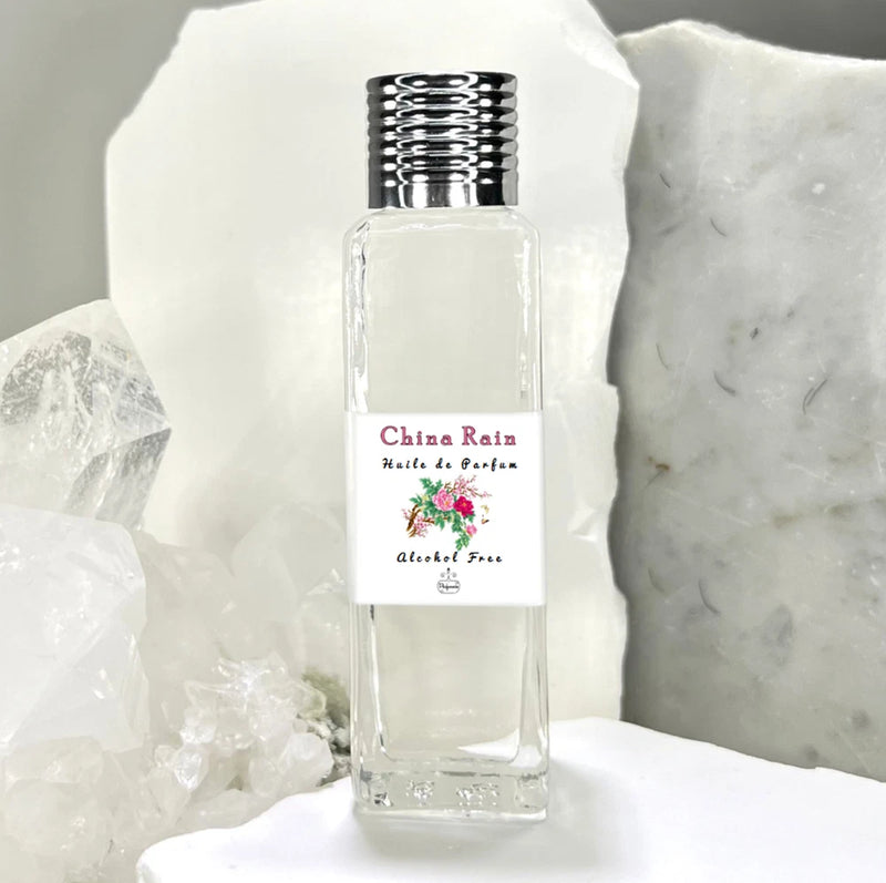 Perfume oil bottle, clear glass with silver ridged cap and floral label