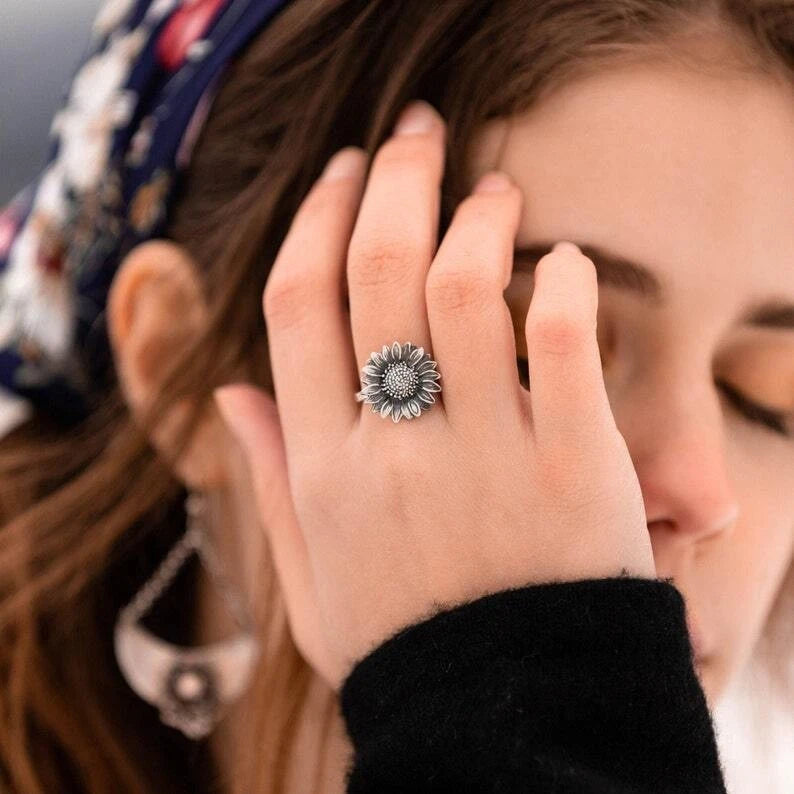Sterling silver sunflower ring with raised flower center, worn on finger