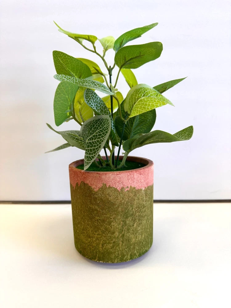 Potted faux indoor shrub plant with green leafy stems in a textured green pot