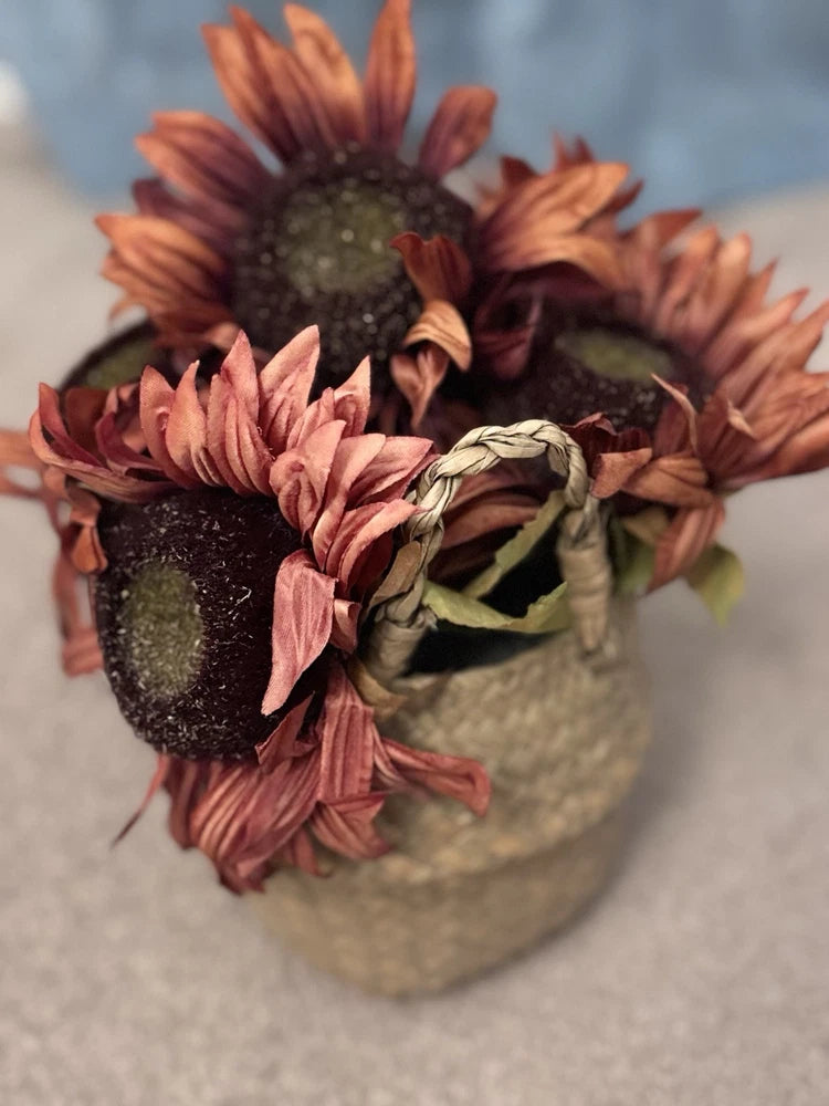 Artificial sunflower arrangement in woven basket with burgundy and dusty pink petals