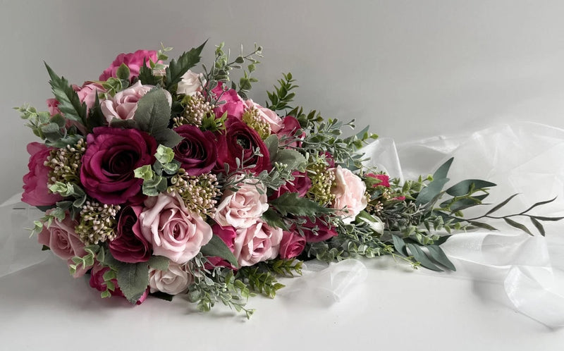 Cascading wedding bouquet with hot pink and dusty pink roses, berry accents, eucalyptus leaves