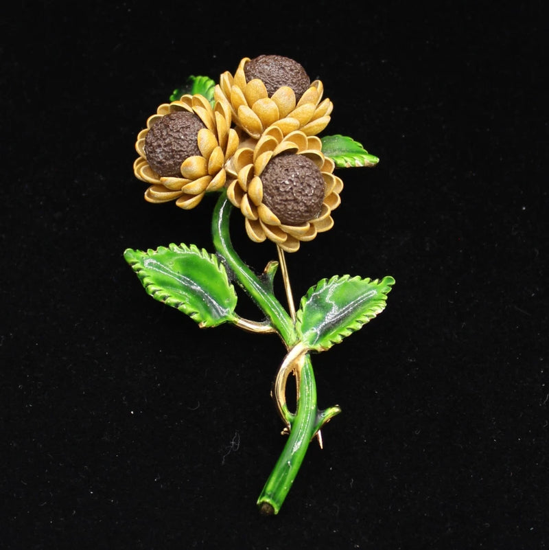 Gold-tone sunflower enamel brooch pin with yellow petals and green leaves
