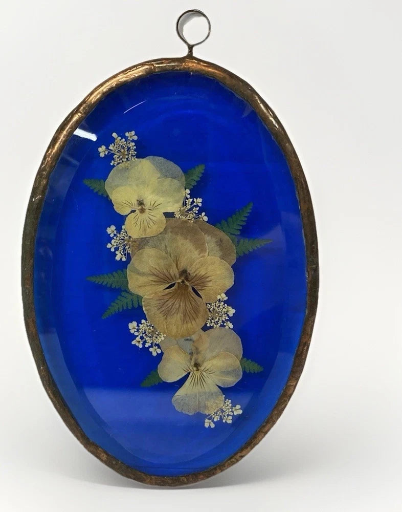 Oval blue glass panel with copper foil frame and pressed dried flowers