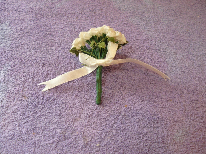Doll bouquet of pale white silk roses with green stems and light ribbon wrap