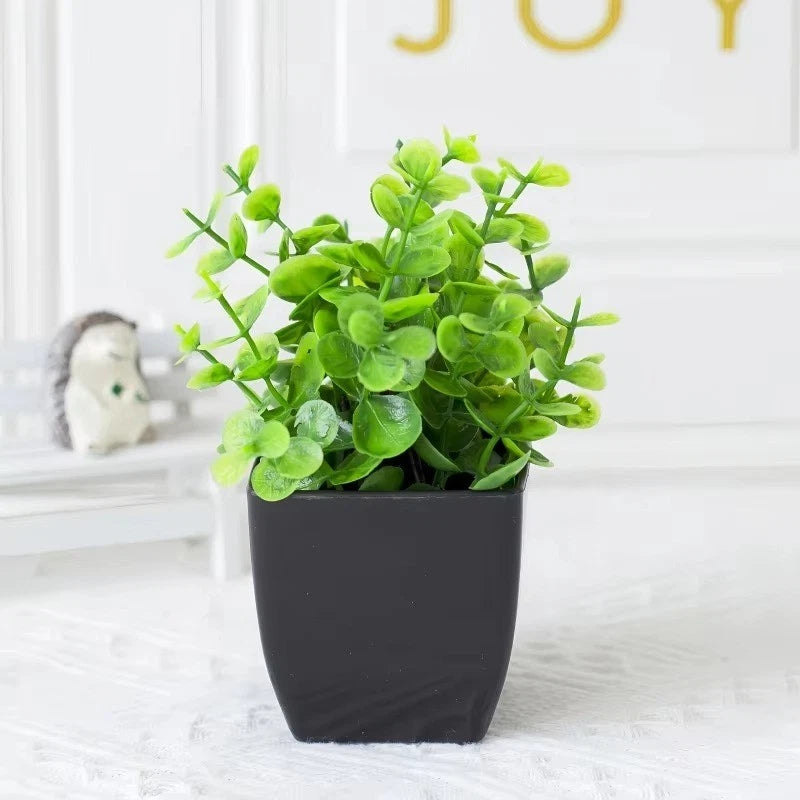 Artificial green plant in a black square pot with dense leafy foliage