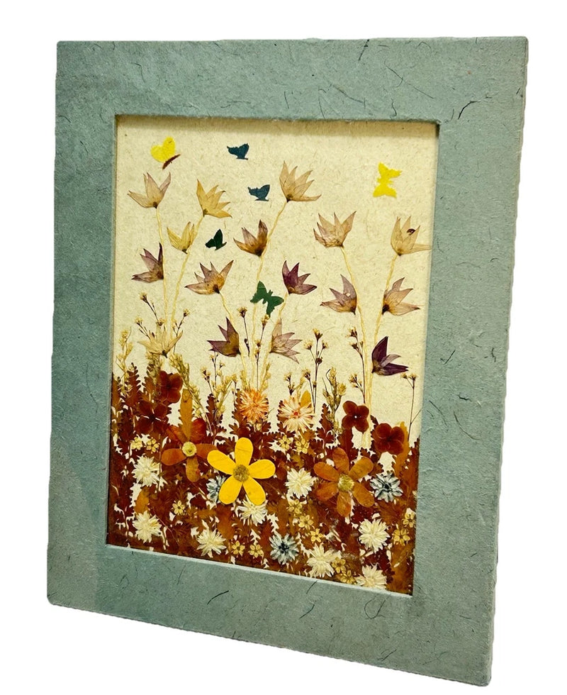 Textured wall decor frame with pressed dried flowers and small butterflies on beige background