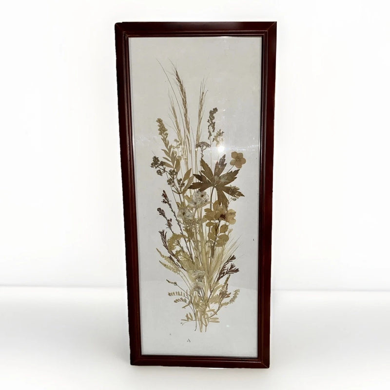 Framed pressed dried leaves and grasses wall hanging in tall rectangular wooden frame