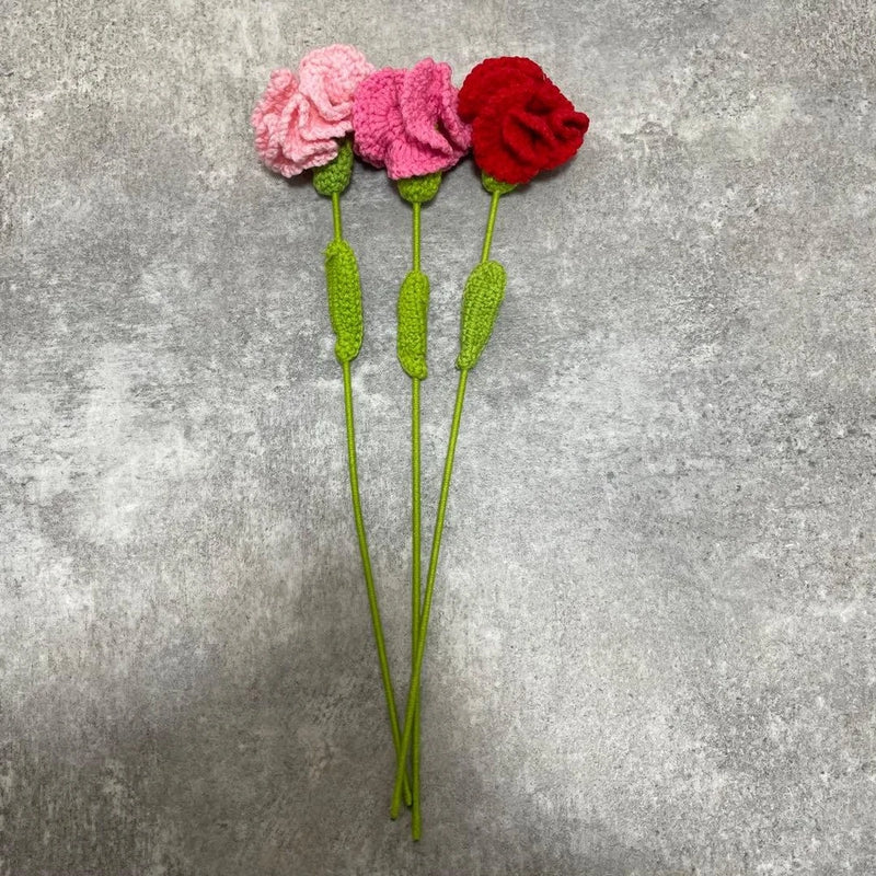 Crochet carnation bouquet with three pink and red flowers on green stems