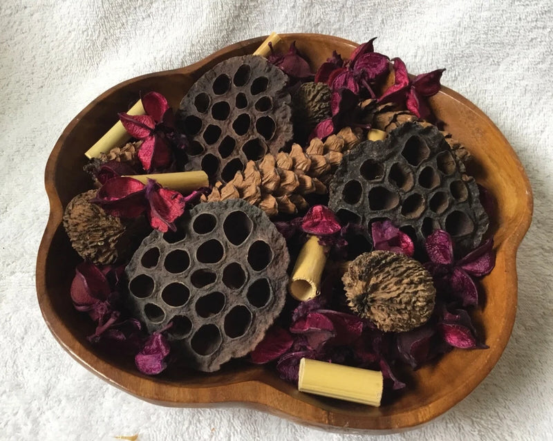 Potpourri arrangement in oval wooden tray with lotus pods, purple petals, dried botanicals