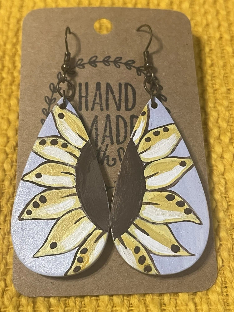 Handmade sunflower drop earrings with black hooks and white, yellow, and black painted petals