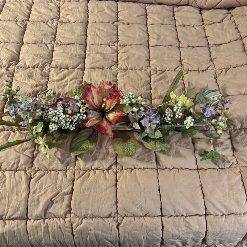 Dried flower wall hanging spray with purple and white buds and a red bloom center