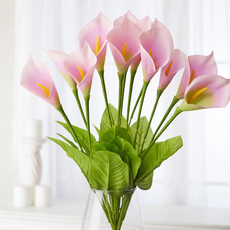 Artificial lavender calla lily floral bush with pink blooms, yellow centers, and green leaves
