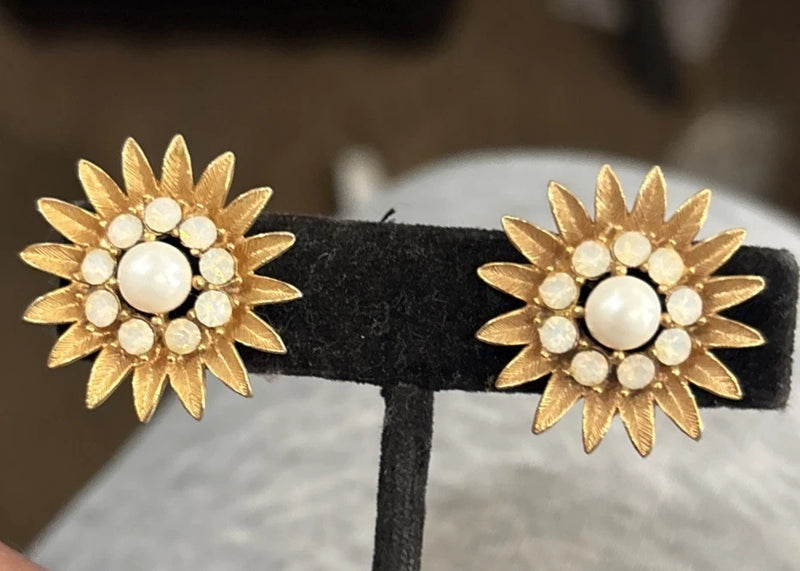 Gold tone sunflower earrings with white pearl-like centers and raised petal details