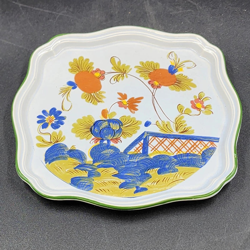 Scalloped ceramic serving dish with green rim and colorful garden floral print