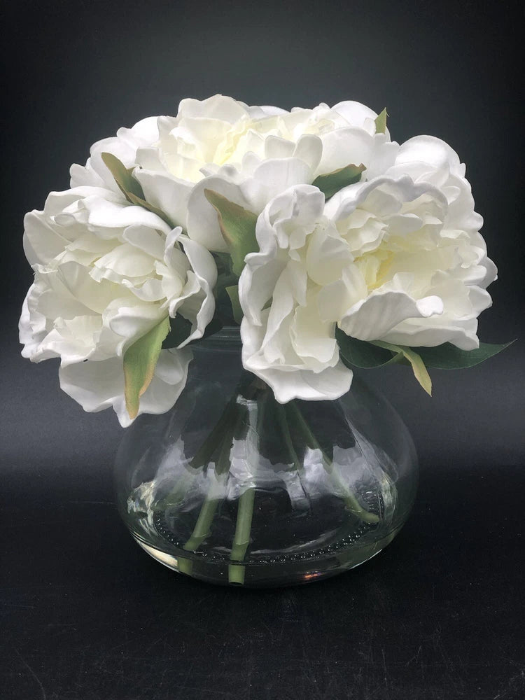 Artificial silk peony flower arrangement in clear glass vase with faux water