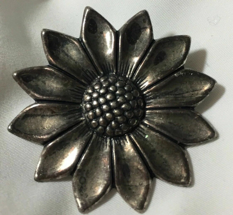 Silver tone metal sunflower brooch pin with raised textured center and petals