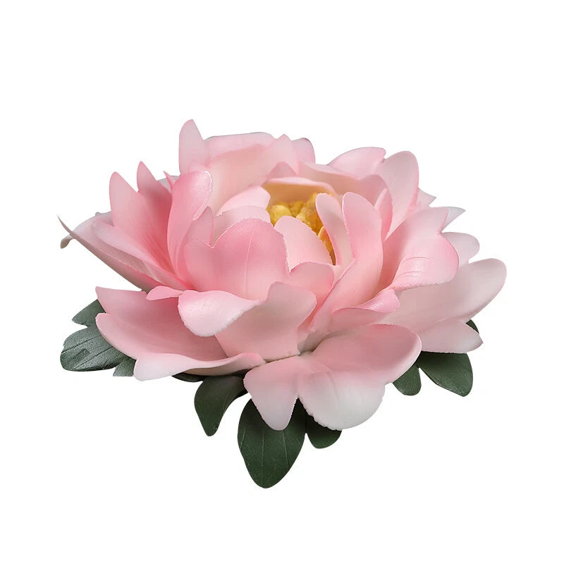 Pink ceramic peony ornament with layered petals and green leaf accents