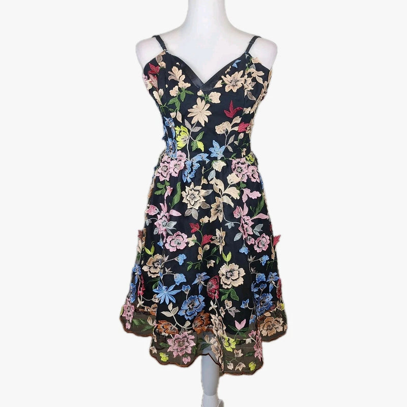Floral embroidered V-neck sleeveless dress with scalloped hem, dark background