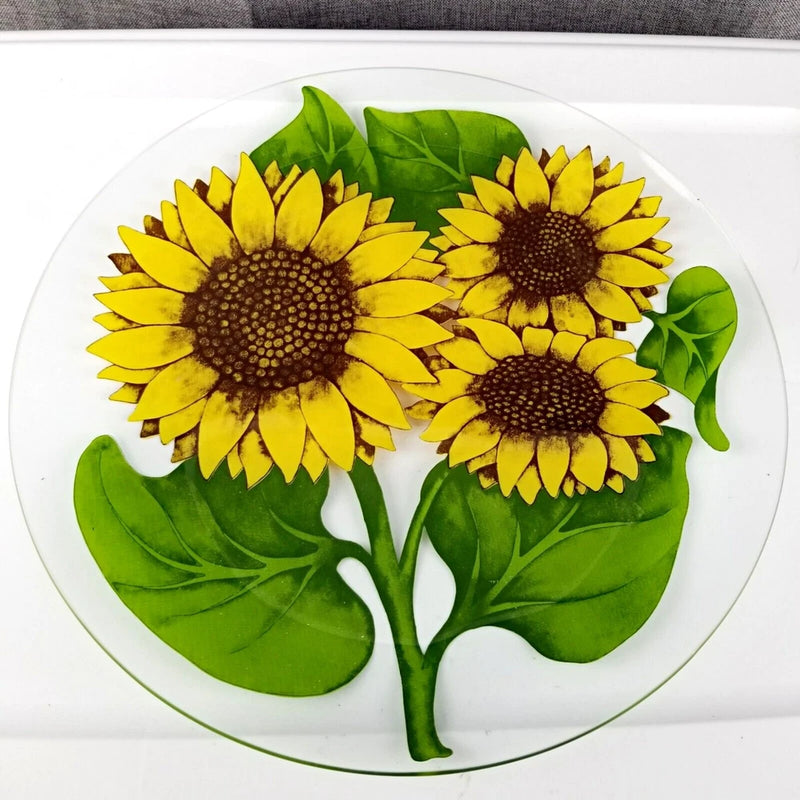 Round glass serving tray with colorful sunflower and green leaf design, yellow centers, 13¼ in