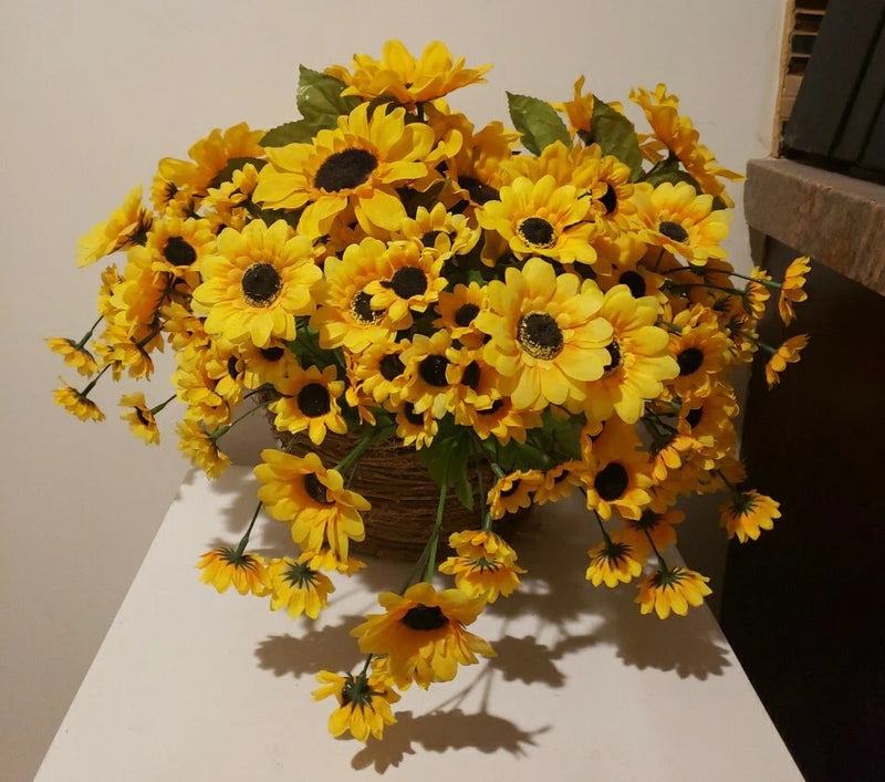 Artificial silk sunflower bouquet in hanging wicker wall basket, yellow blooms with green leaves