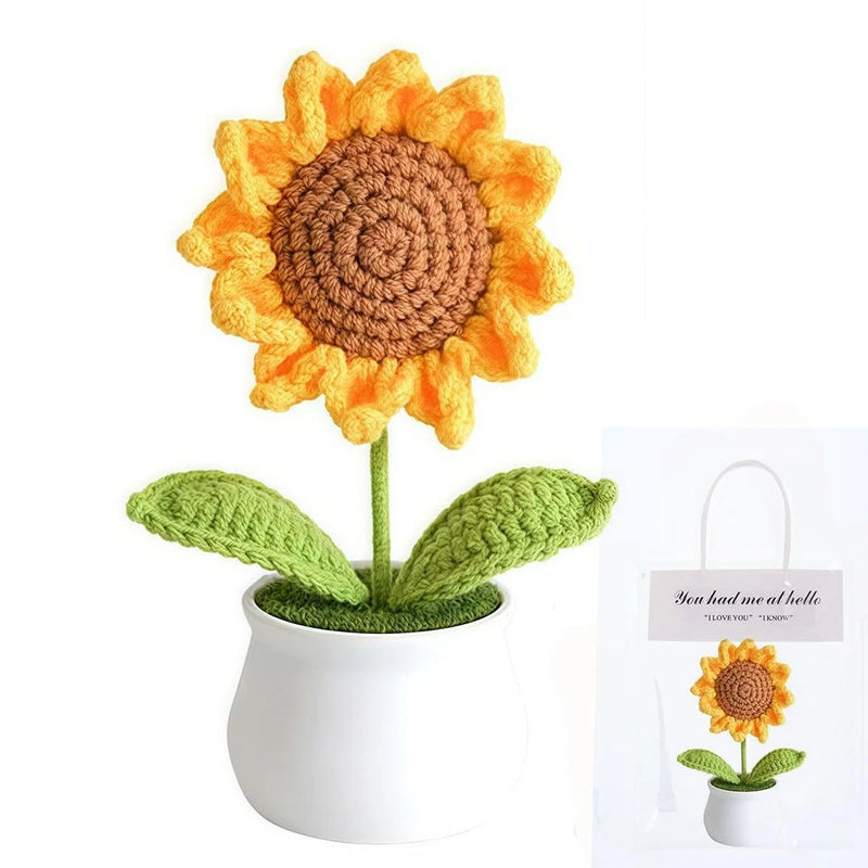 Crochet sunflower decoration with yellow petals and green leaves in white pot