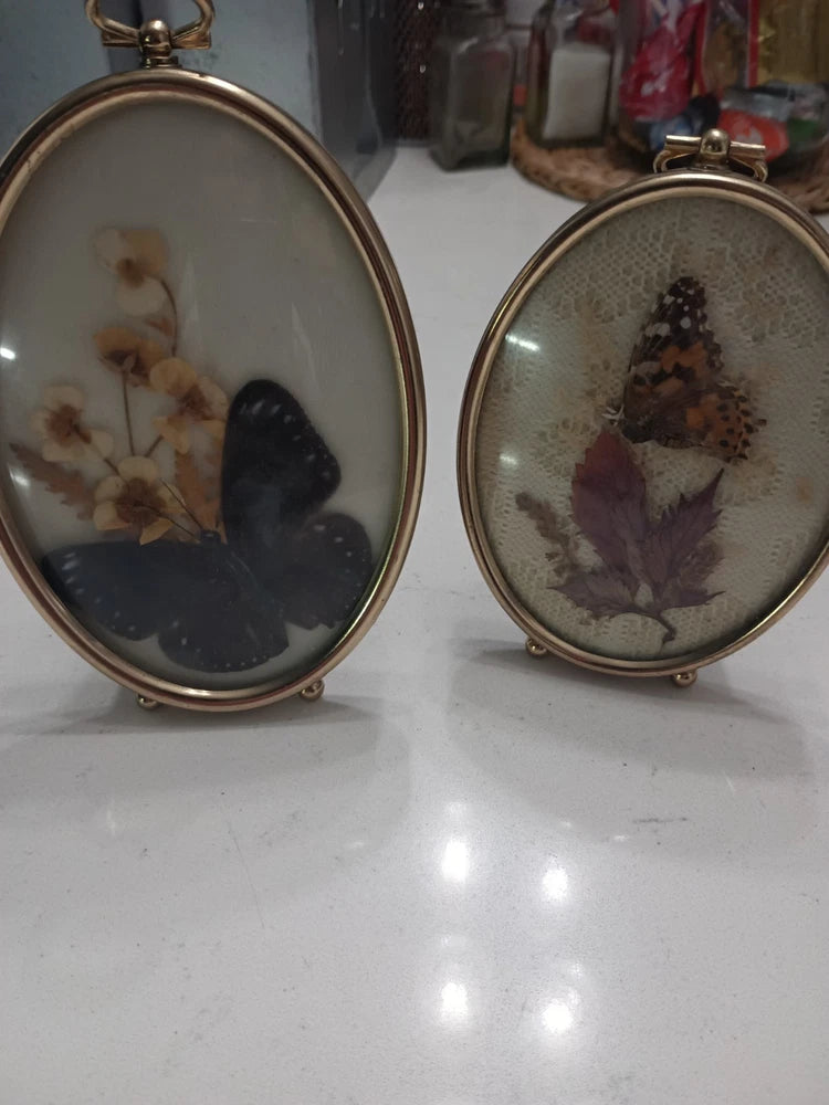 Gold-tone oval frame standing display with dried flowers and butterfly decor (pair)