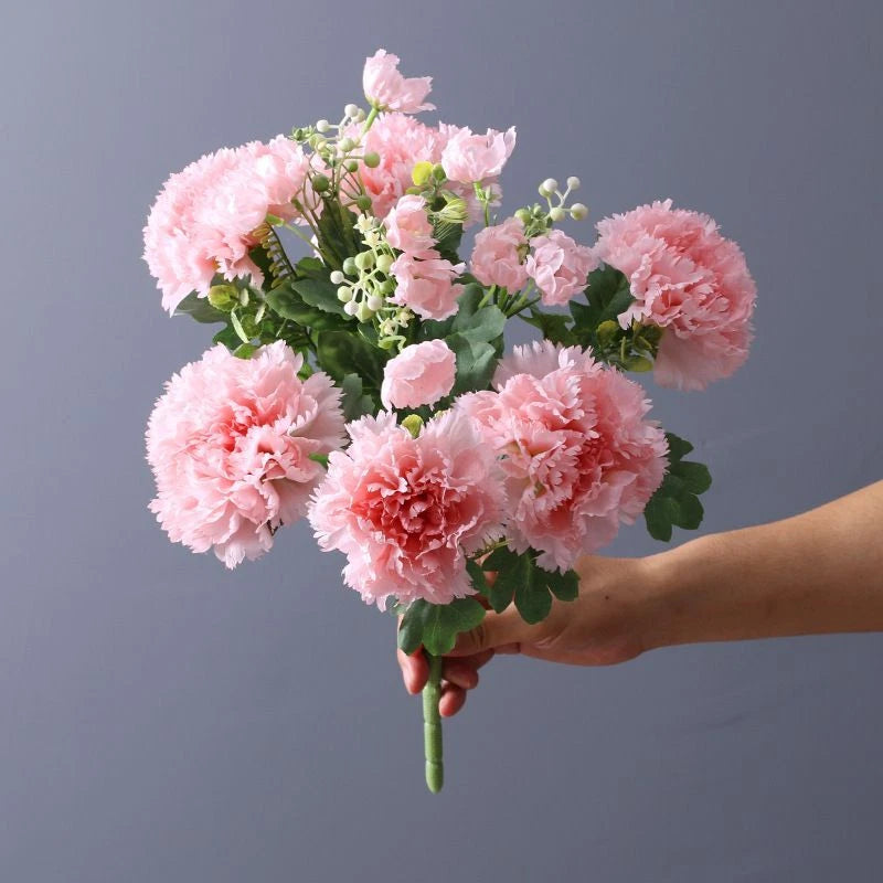 Artificial pink carnation flower bouquet with green leaves on stems