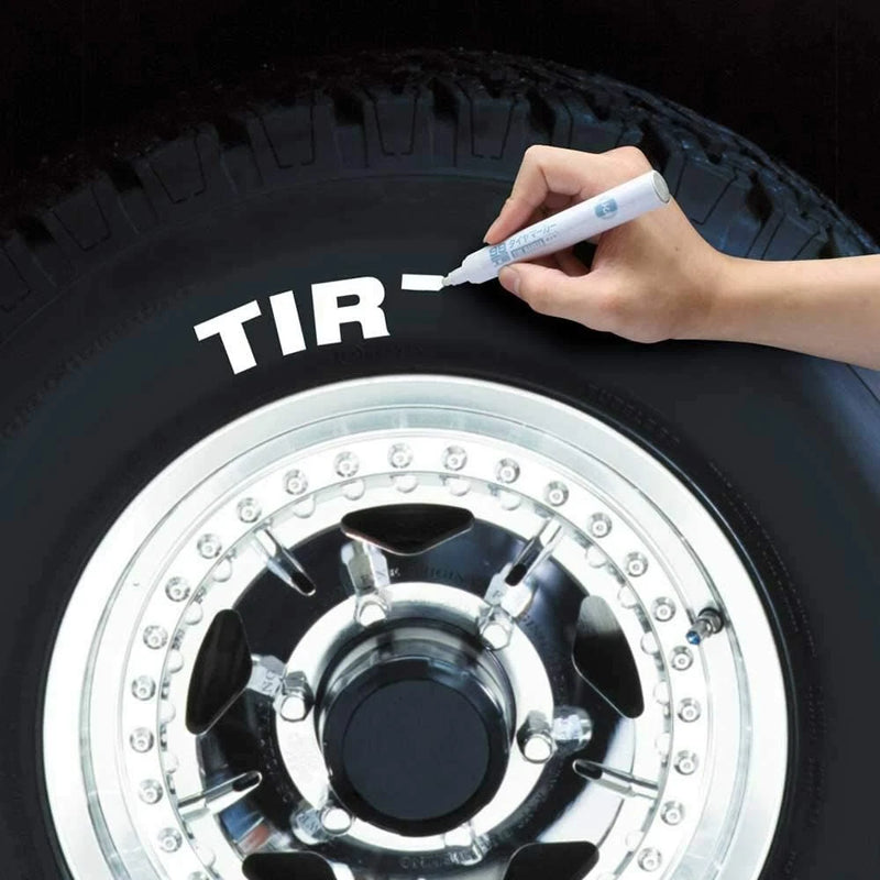 Waterproof paint marker pen in hand, marking lettering on black tire sidewall