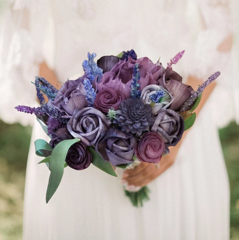 Purple plum wildflower bridal bouquet with mixed purple roses, blue blooms, and greenery leaves