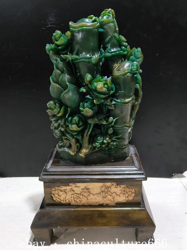 Green peony-and-bamboo stone statue with ornate carving on rectangular base
